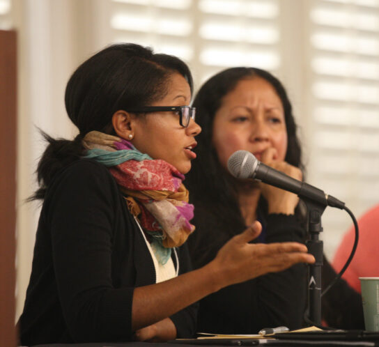 Woman speaking into a microphone on a research panel