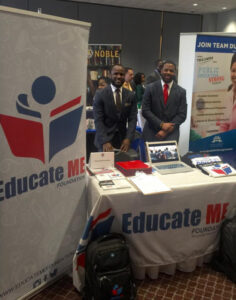Two men standing behind an 'Educate Me' tradeshow booth