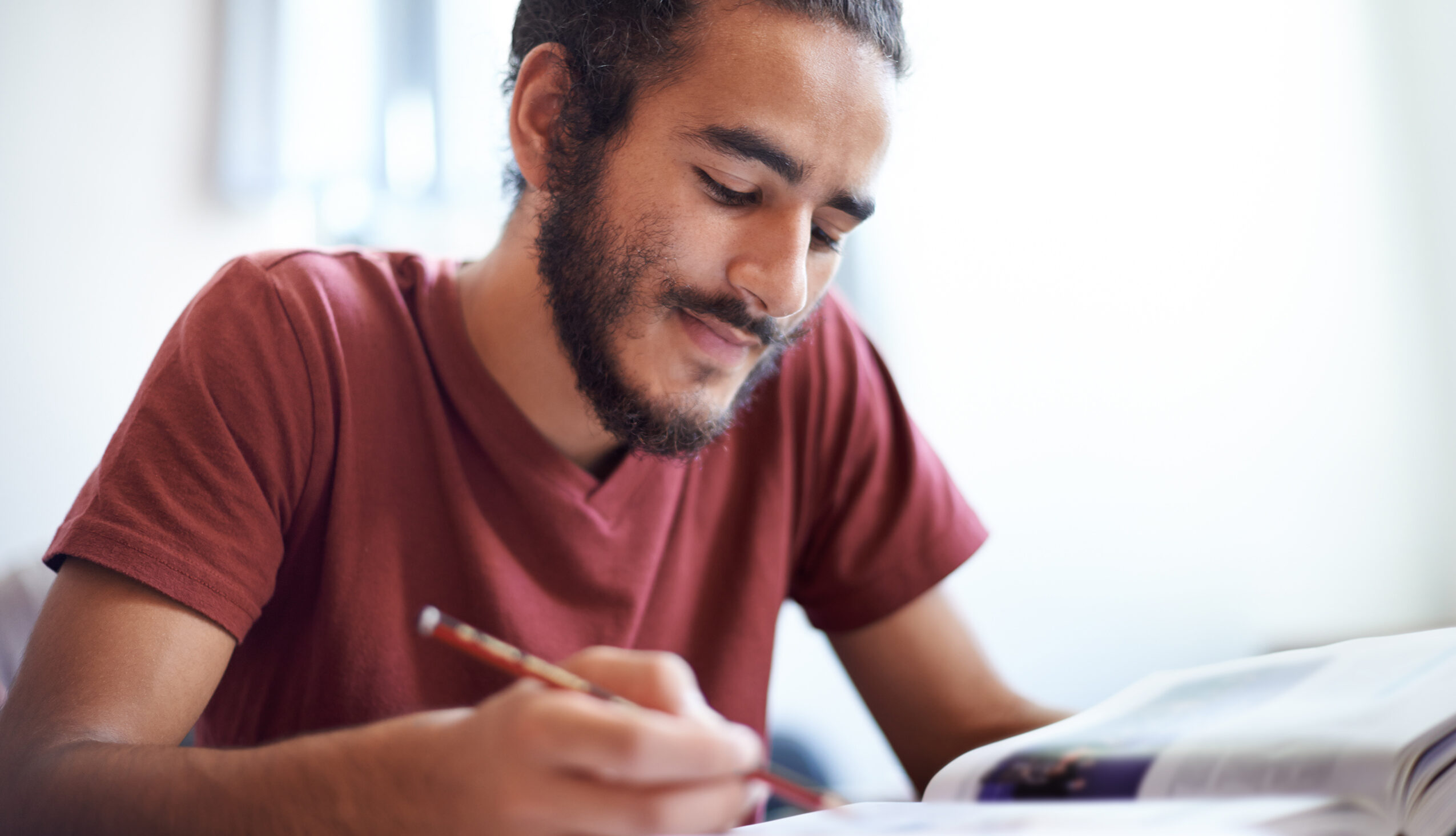 ph.d. student researching and taking notes from a book