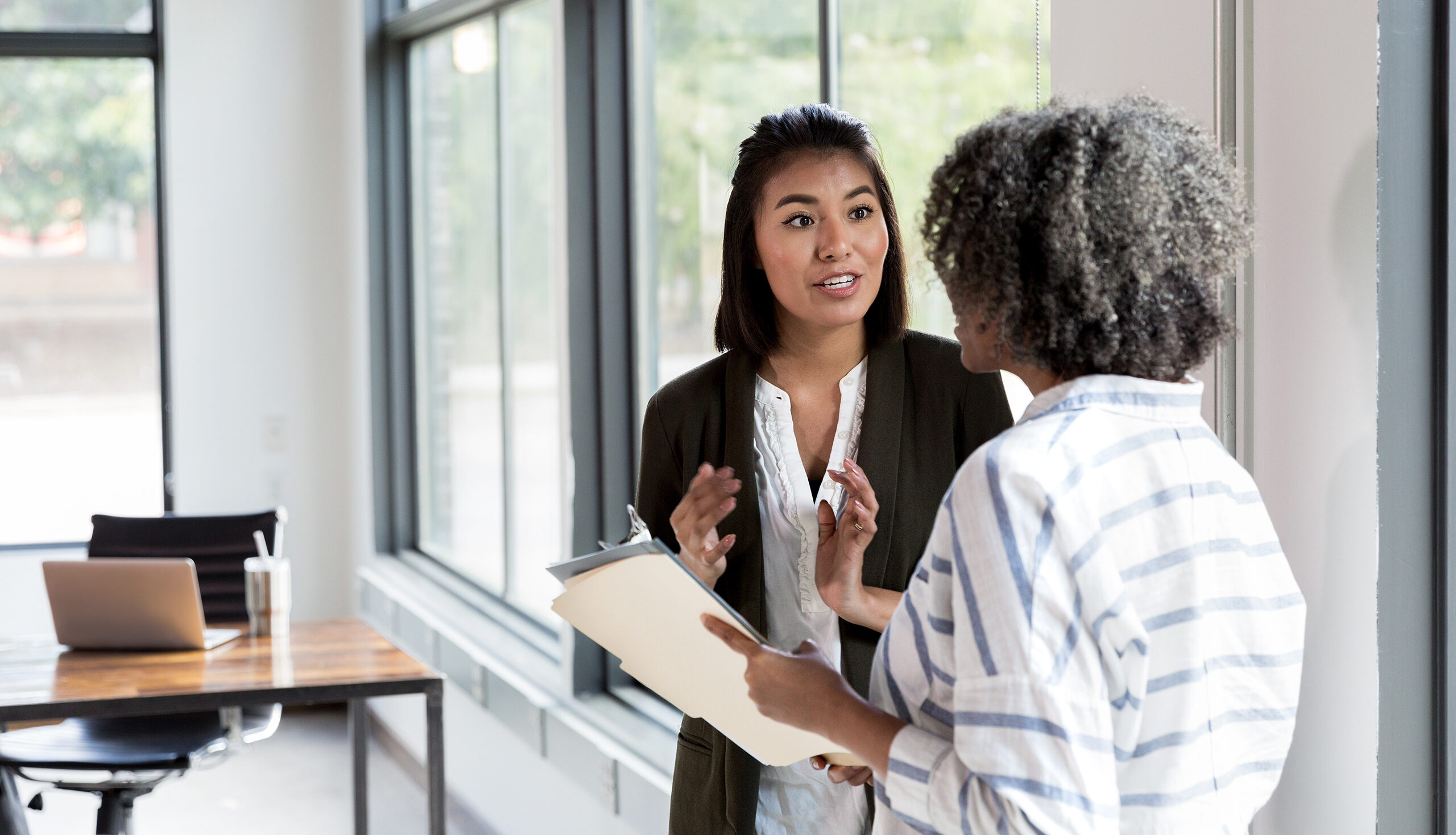 One woman talking to another in an office