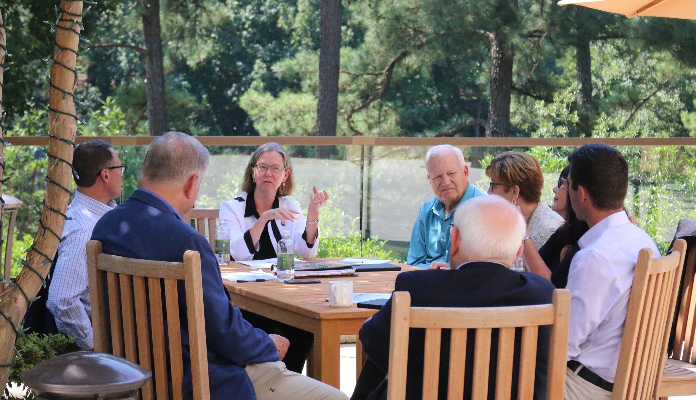 education and policy leaders in conversation around a table outside