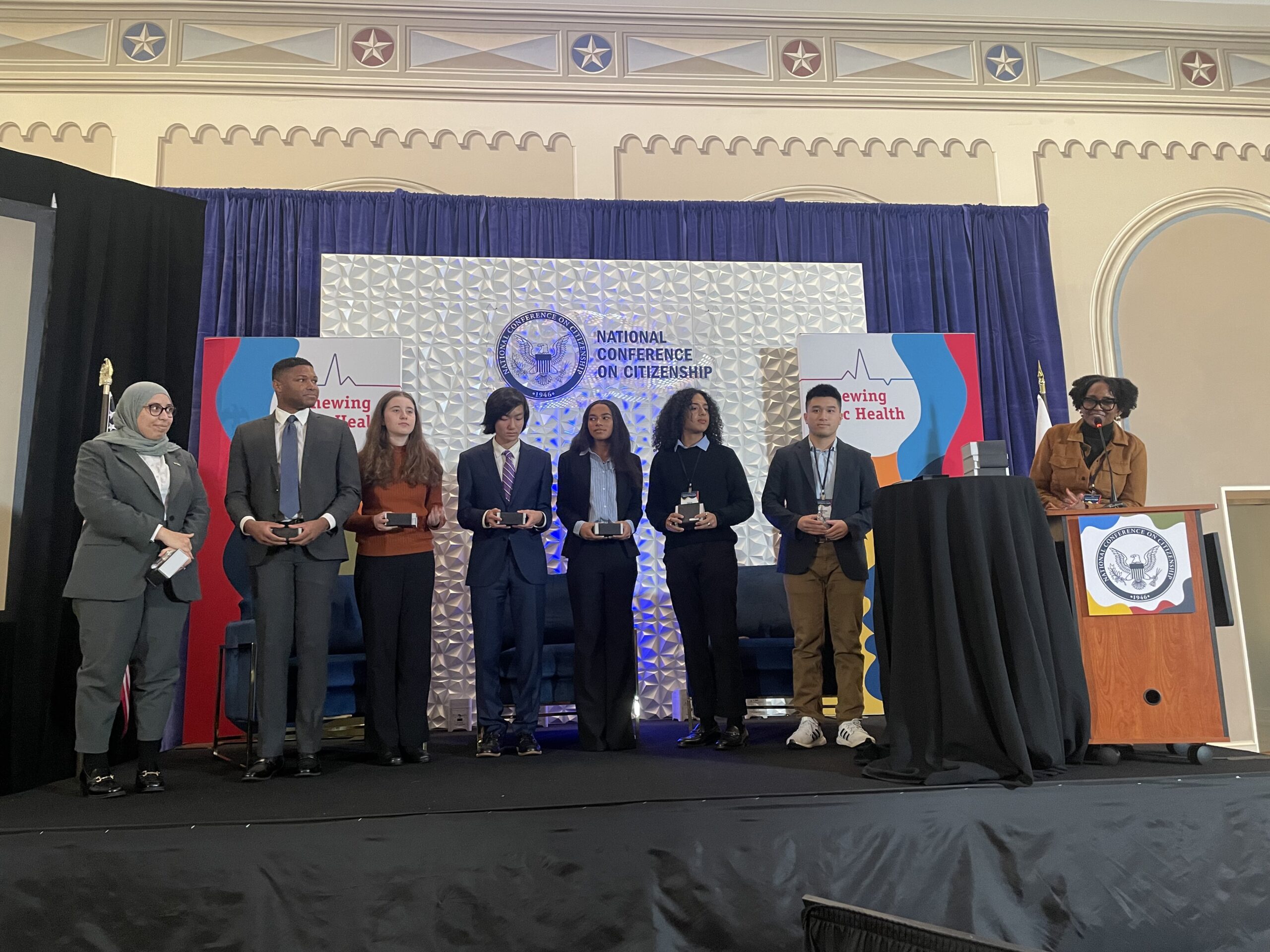 group of people on a stage accepting an award