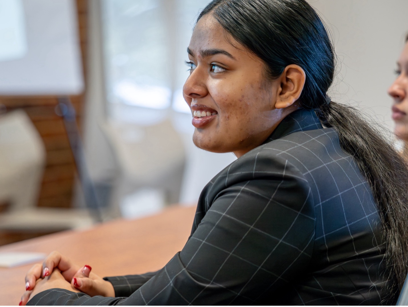 woman smiling while watching a presentation