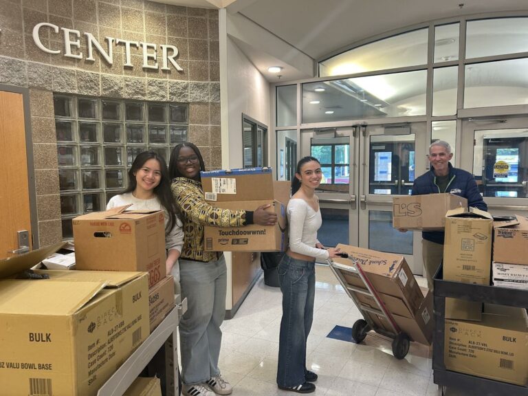 Group of young people and older adult transporting boxes